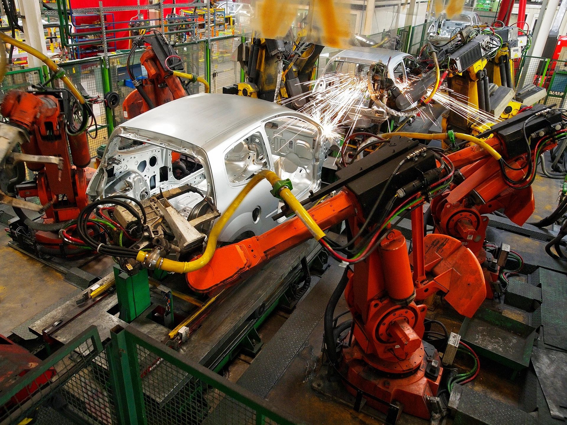Robots assembling cars in a factory.
